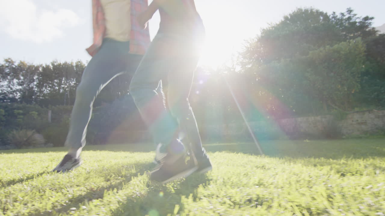 Playing soccer on grass, Indian father and son enjoying outdoor activity together