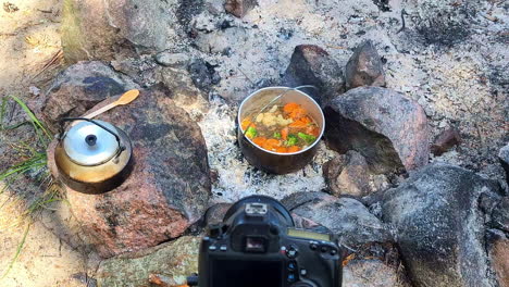 filming point of view pov, pot of stew, slow cooking in hot charcoal