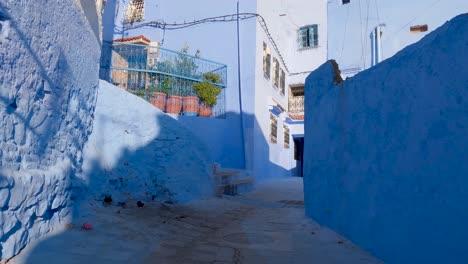 pov walking up steep street in chefchaouen leading to small courtyard