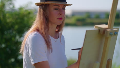 woman painting outdoors by the lake