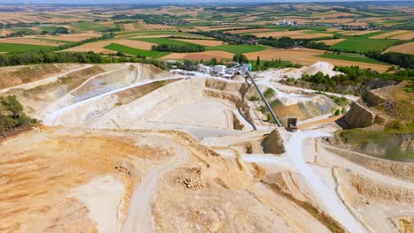 cantera de minería a cielo abierto con maquinaria en el trabajo - toma aérea