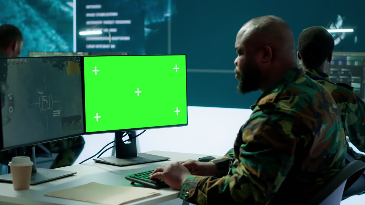especialista militar monitorea los datos de satélite junto a la pantalla verde