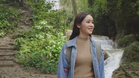 Asian Woman Walking In Front Of A Waterfall, Slow Motion