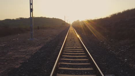 pov of a train running on rail tracks in india at golden hour