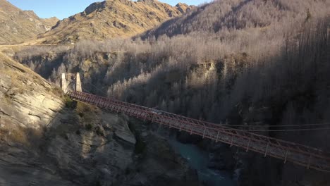car driving across bridge over a canyon along a four wheel drive track during sunset.