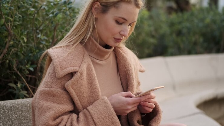 Giovane donna che usa il telefono all'aperto