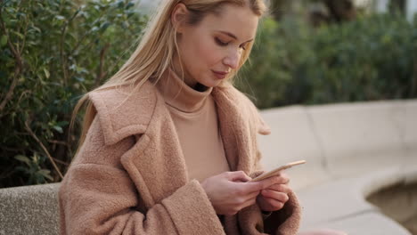 Mujer-Joven-Usando-El-Teléfono-Al-Aire-Libre.