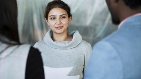 mujer joven tranquila hablando con colegas