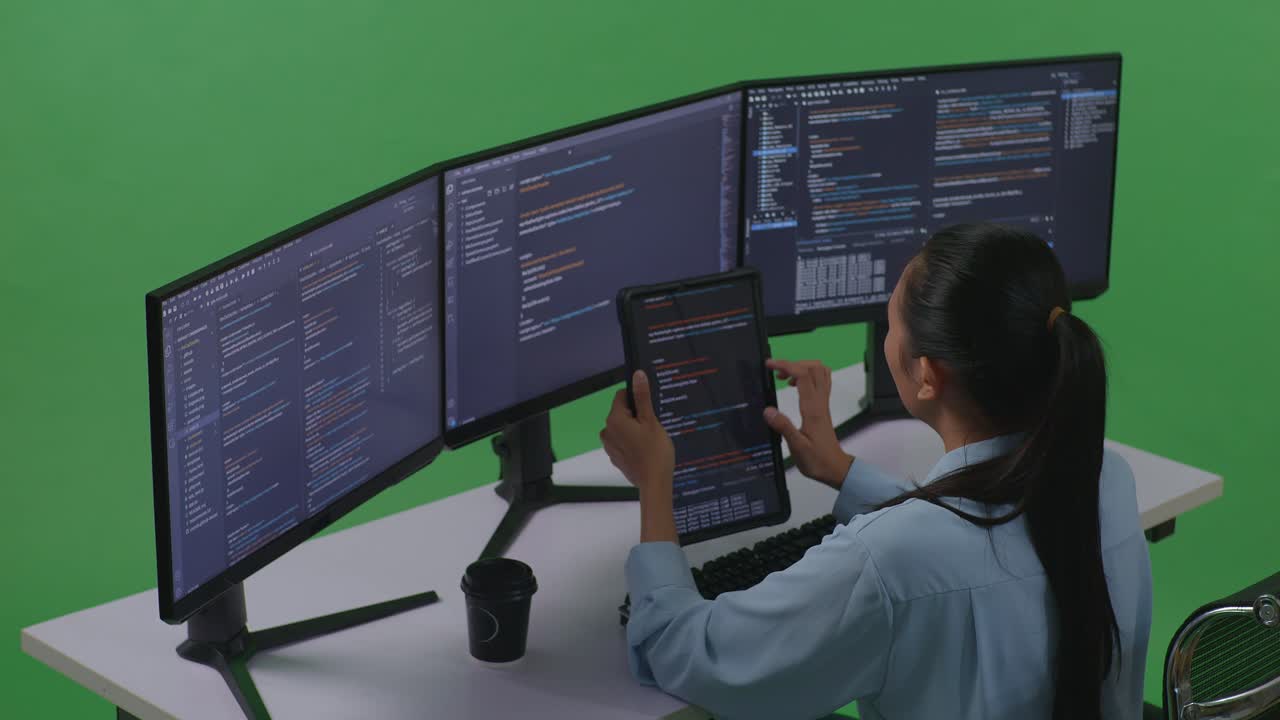 mujer programadora trabajando en múltiples pantallas