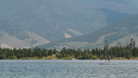 two people riding paddleboards across lake dillon in colorado's frisco adventure park