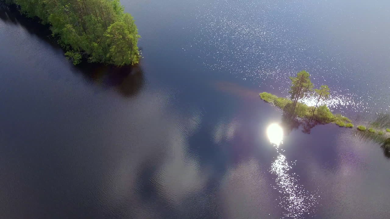 Beautiful bank turn drone video of a small cape in a Finnish forest lake