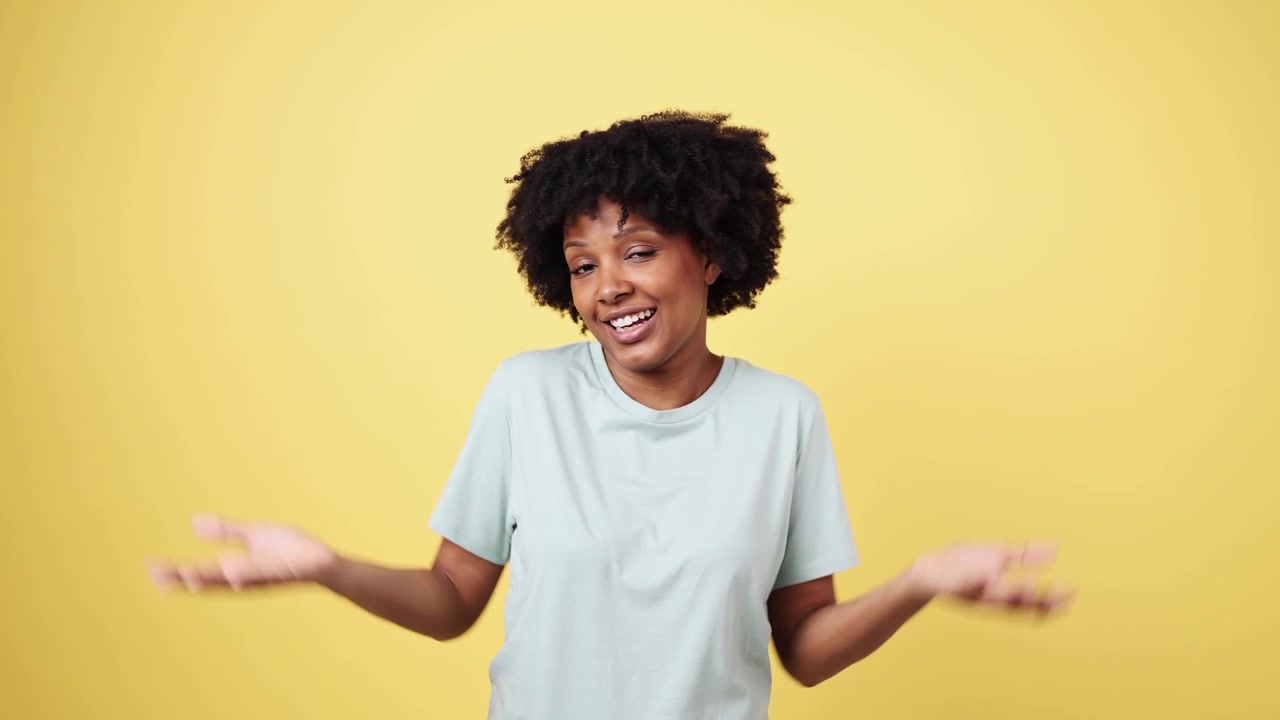 Happy Young African American Woman Waving and Shrugging