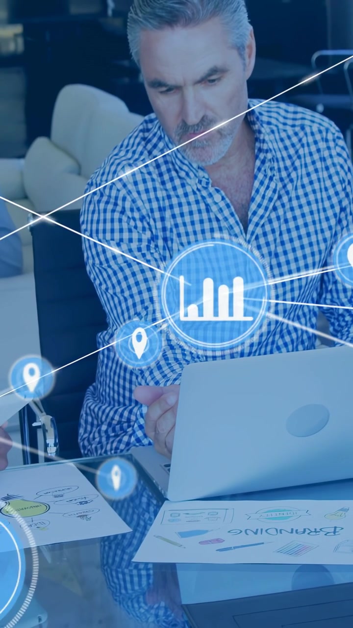 Vertical video: Man in checked-shirt using laptop initiating business HUD linking charts for review