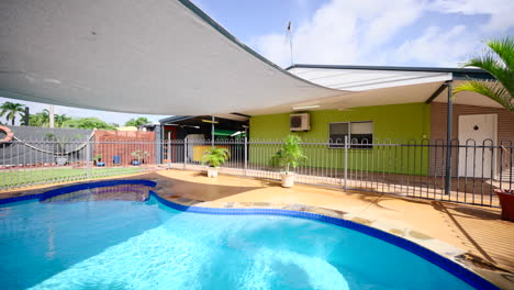 colourful home pool shimmers light across tropical shadows on cool water under shade covering