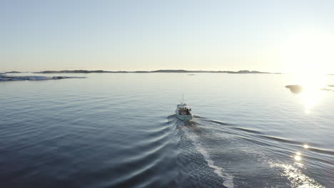 drone shot of a fishing boat sailing out at sea at gothenburg archipelago, sweden