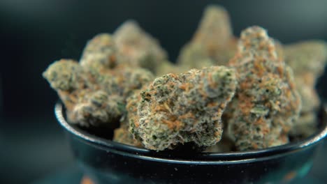 una foto de sueño macro de una planta de cannabis, variedades híbridas de naranja, sativa, flor de marihuana, en un soporte giratorio, cámara lenta, video 4k, iluminación de estudio