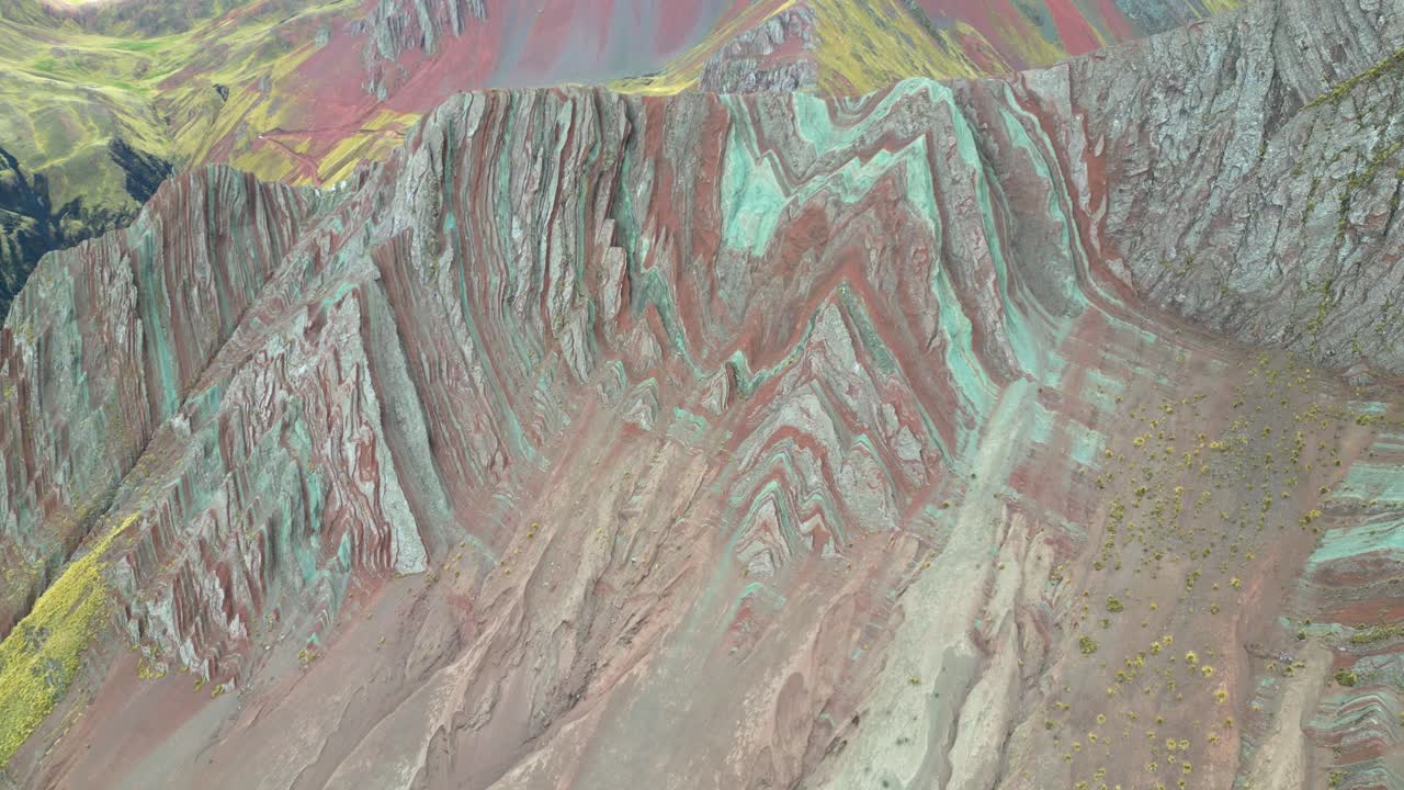 Sweeping aerial shot of colourful, razor-edged mountains in southern Peru. The scene captures the raw beauty of the lesser-visited Rainbow range