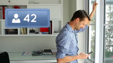 hombre enviando mensajes de texto en su teléfono cerca de una ventana