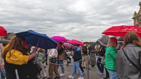 crowd with umbrellas near louvre on a rainy day