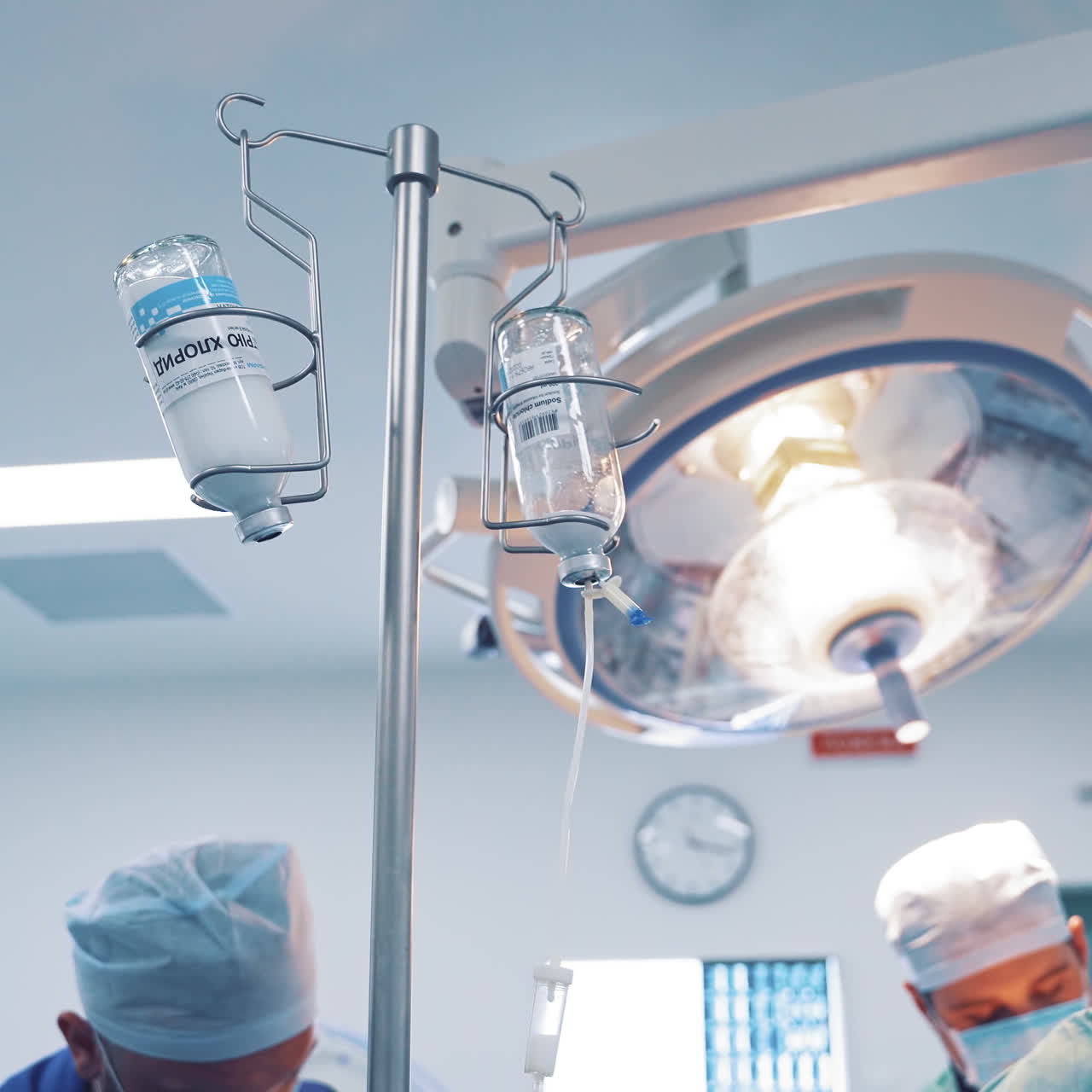 Two chemotherapy bottles hanging from a tripod during operation in clinic. Medical equipment in the operating room.