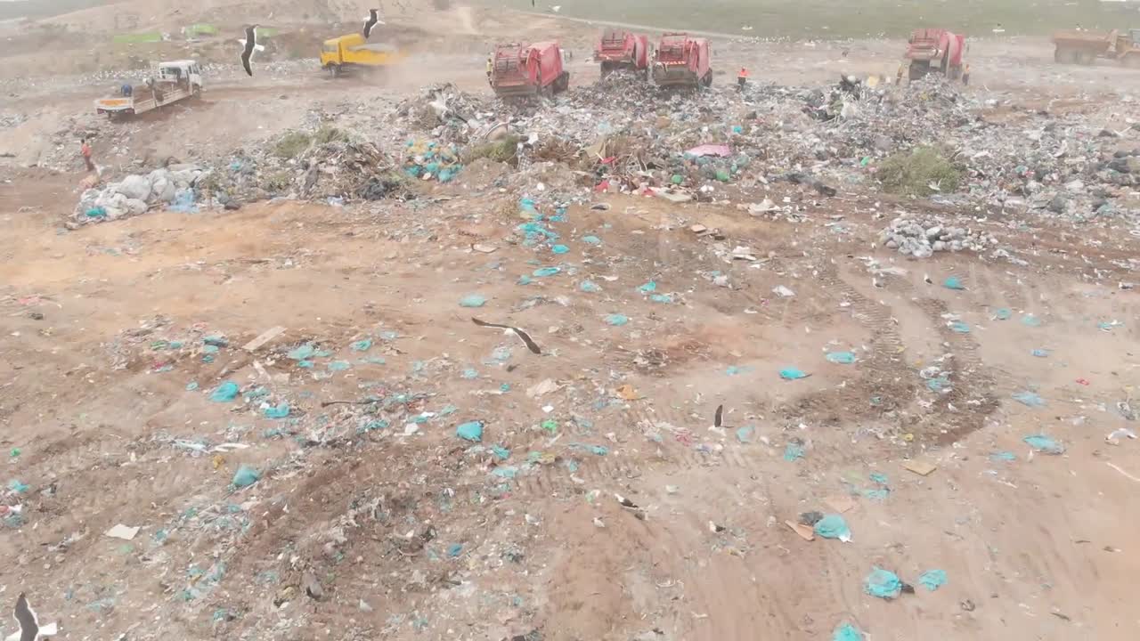 vehículos que limpian la basura apilada en un vertedero lleno de basura