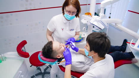 Medical teeth health care. Doctor with assitant taking care by patient teeth.