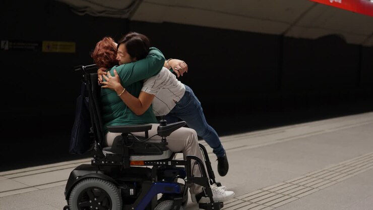 A heartfelt hug between two women, one using a wheelchair