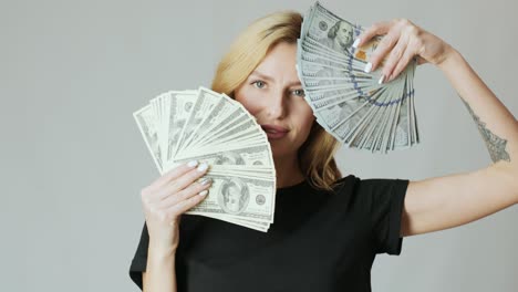 beautiful girl with a lot of dollars in the hands on the white background