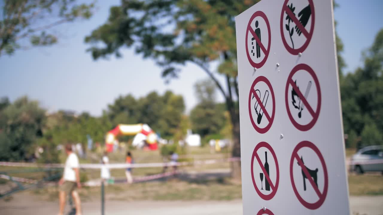 금지 포스터, 금지 표지판, 클로즈업, 공원 지역에 금지 표시판이 붙은 포스터, 배경이 흐릿하다.