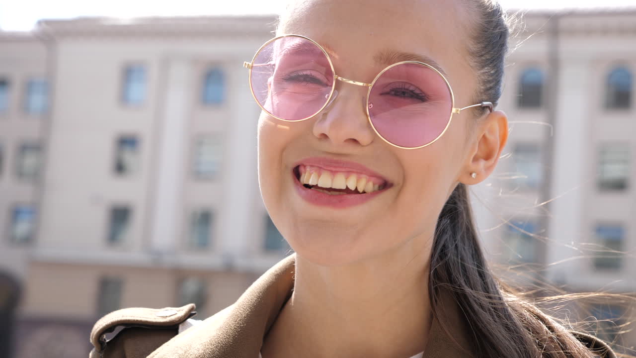 mujer feliz con gafas de sol rosas