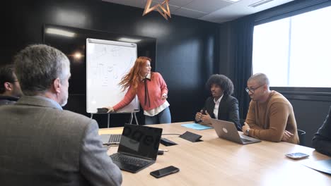group of colleagues listening to female speaker