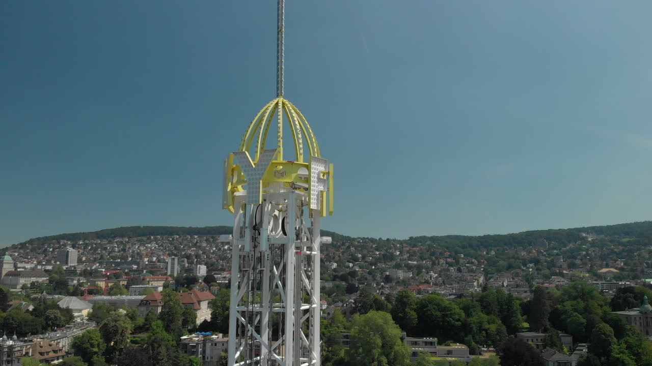 취리히 페스트 기간 동안 스위스 취리히에 있는 놀이 공원 자유 낙하 탑 주위를 공전하는 공중 드론 샷