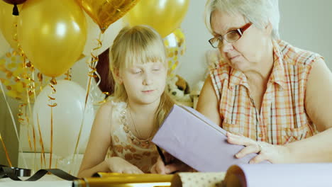 grandmother and granddaughter pack presents together active seniors concept