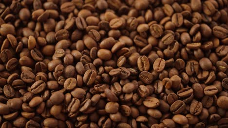 coffee beans falling in slowmotion on a bed of roasted coffee beans topshot