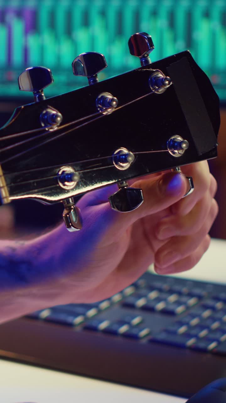 Primo piano di una mano che accorda una chitarra acustica in uno studio musicale