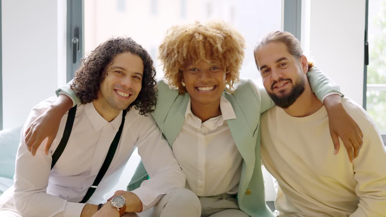 Colleagues smiling at the camera sitting relaxed on a coworking