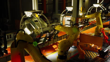 automated robotic arms working on a conveyor belt in a production facility