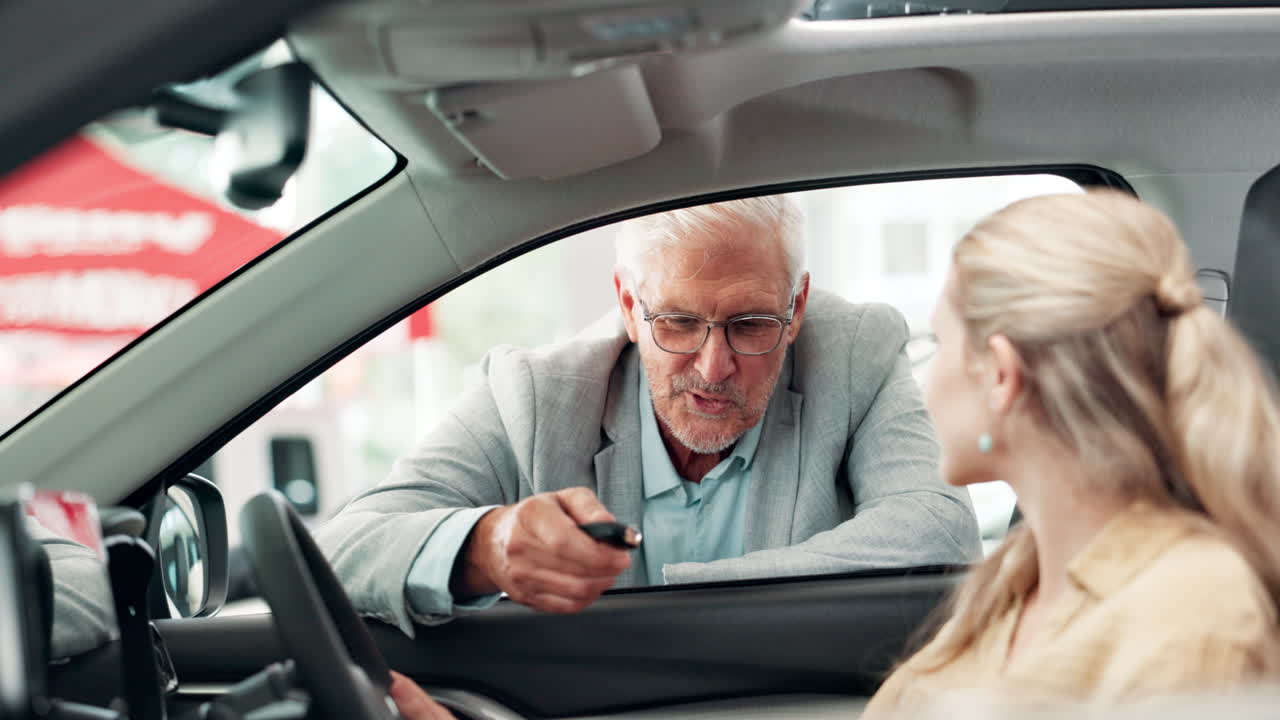 A customer receives the keys to a new car from a salesman