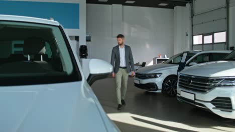 man looking at cars in a showroom