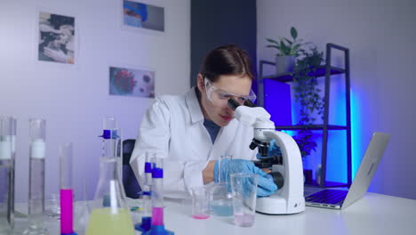 científico que trabaja con el microscopio en un laboratorio