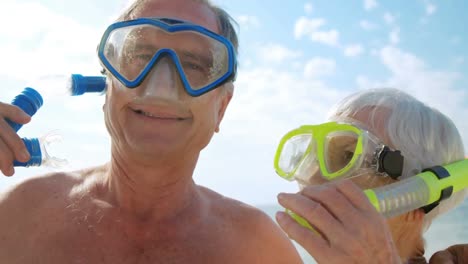 Animation-of-do-it-for-them-over-caucasian-senior-couple-with-snorkeling-masks-on-beach