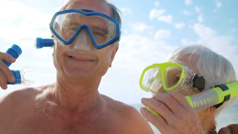 animación de hacerlo por ellos sobre una pareja de ancianos caucásicos con máscaras de snorkel en la playa