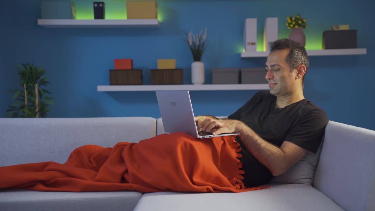 hombre enviando mensajes de texto en la computadora portátil.