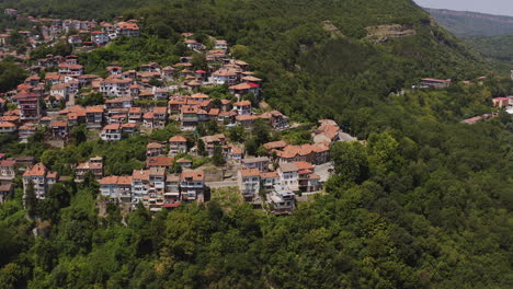 hillside city of veliko tarnovo among green woodland aerial panorama