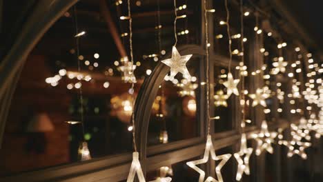 vintage street decoration of restaurant for the winter holidays. christmas lights holiday background of garlands of glowing stars at night. new year. blur, bokeh for your design