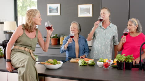 Un-Grupo-Diverso-De-Mujeres-Mayores-Disfrutan-De-Vino-Y-Ensalada-En-Una-Cocina-Moderna