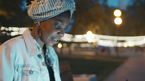 black woman using laptop outdoors in evening