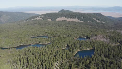 beautiful slow motion aerial view of the sky lakes wilderness, small lakes in between the wilderness of a forest in a mild cold climate in a natural background