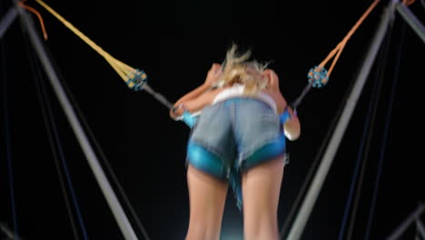 person jumping on a bungee trampoline at night
