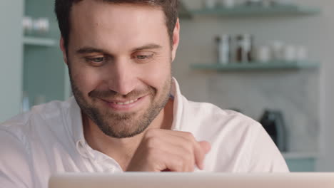 attractive young man using laptop computer browsing online enjoying successful lifestyle relaxing at home looking out window planning ahead